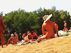 Wives and their husbands sunbathing at the nudist beach