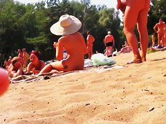 Wives and their husbands sunbathing at the nudist beach