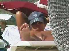 Oiled babe with trimmed vagina taking sunbaths on the beach