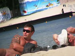 Wide spread pussy lying on a beach in this spy cam video