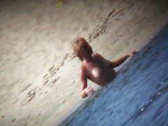 Mature babe with beautiful breasts gets all wet at nudist beach