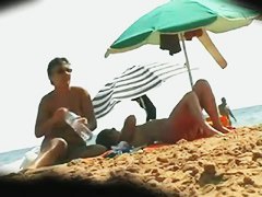 two unshaven lesbians on the beach relaxing and stroking each other