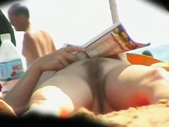 two unshaven lesbians on the beach relaxing and stroking each other