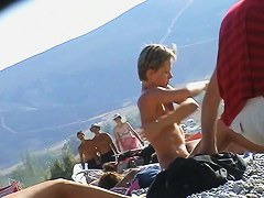 Nude beach cam catches slim blonde oiling her hot body