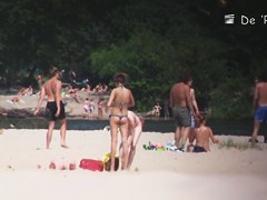 Beach nudist lying on the sand and showing his dick