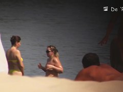 Beach nudist lying on the sand and showing his dick