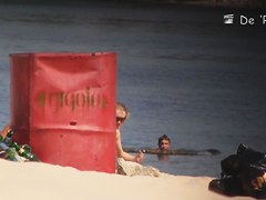 Beach nudist lying on the sand and showing his dick