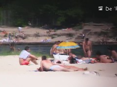 Beach nudist lying on the sand and showing his dick