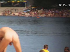 Beach nudist lying on the sand and showing his dick