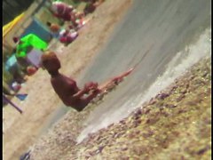 Sexy blonde chick is sitting naked by the sea and relaxing