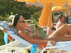 Hot video of a mature woman reading a book on a nudist beach