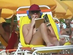 Hot video of a mature woman reading a book on a nudist beach