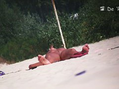 Nude beach voyeur shot of two hot brunettes sunbathing