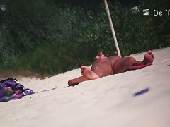 Nude beach voyeur shot of two hot brunettes sunbathing