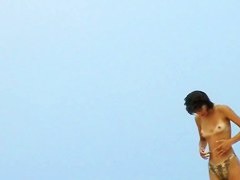 Topless sleek hotties on the nude beach getting filmed by a voyeur