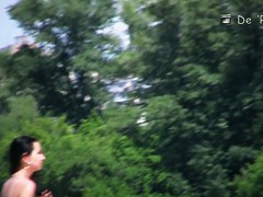 Girl is covering nude tits with hands on beach voyeur cam