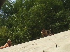 Spy camera on a nudist beach focuses on a sexy brunette