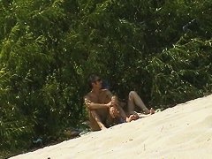 Spy camera on a nudist beach focuses on a sexy brunette