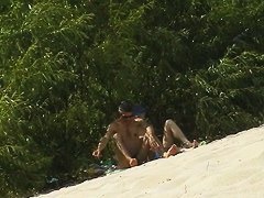 Spy camera on a nudist beach focuses on a sexy brunette