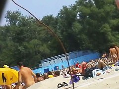 Spy camera on a nudist beach focuses on a sexy brunette