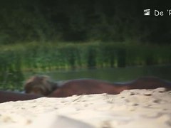 Babe with small tits and shaved vagina relaxes on the beach