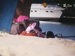 Babe with small tits and shaved vagina relaxes on the beach