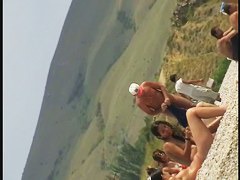 Nudist girls splashing around and playing in shallow water