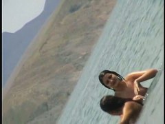 Nudist girls splashing around and playing in shallow water