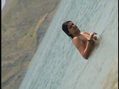 Nudist girls splashing around and playing in shallow water