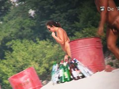 Beach nudist couple having sex in water on voyeur cam