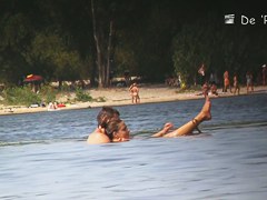 Beach nudist couple having sex in water on voyeur cam