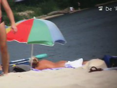 Busty chick caught off guard by a nude beach voyeur