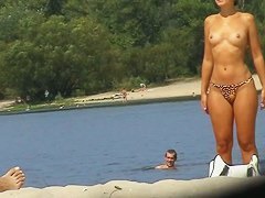 Topless girls sunbathing and having fun on a beach