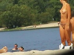 Topless girls sunbathing and having fun on a beach