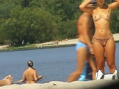 Topless girls sunbathing and having fun on a beach