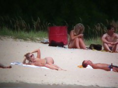 Busty blonde nude beach MILF spied on by a voyeur