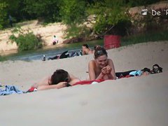 Beach voyeur video of shy topless girl sunbathing