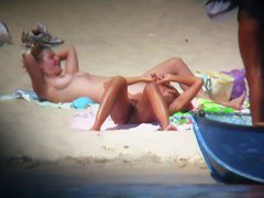 Blonde naked woman on the beach reading a newspaper