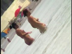 Voyeur view of fun in the water on a nudist beach