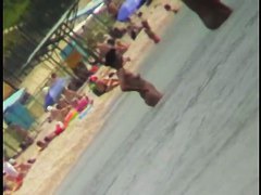 Voyeur view of fun in the water on a nudist beach