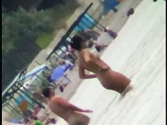 Voyeur view of fun in the water on a nudist beach