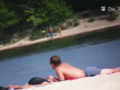 Voyeur beach nudist girl getting suntanned among bikini gals