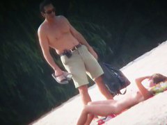 Spy cam shot of a hot nudist blond tanning on the beach