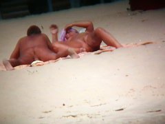 Couple exposing for the hidden cams at the beach
