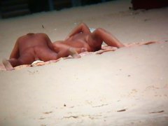 Couple exposing for the hidden cams at the beach