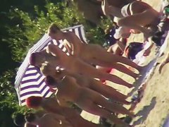 Mature babes with sexy bottoms move naked on the beach