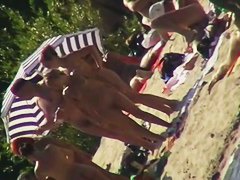 Mature babes with sexy bottoms move naked on the beach