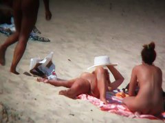 Mature blonde spreading her shaved pussy on the beach