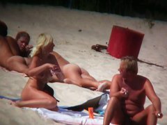 Mature blonde spreading her shaved pussy on the beach