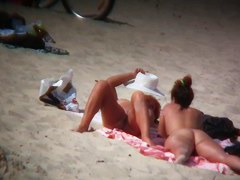 Nude sun tanning girls expose themselves to a beach spy cam